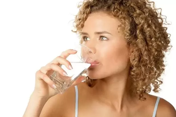 The girl follows a lazy diet, drinking a glass of water before meals